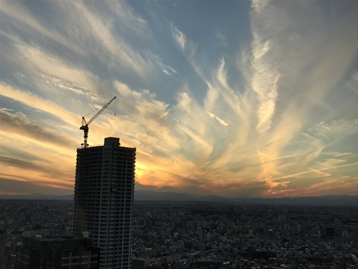 夕暮れと建設中のビルの写真